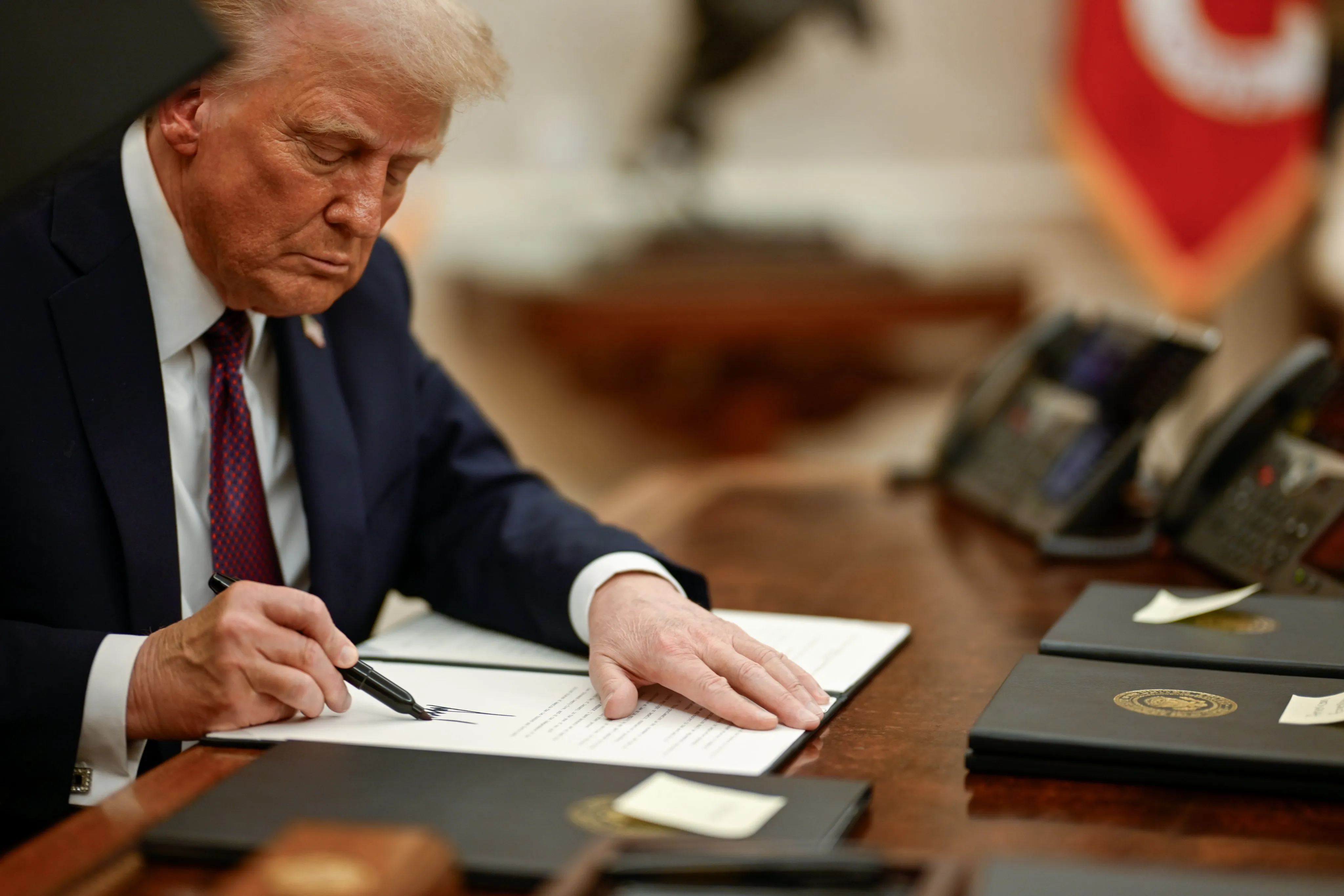 President Donald Trump signing executive orders at the Resolute Desk